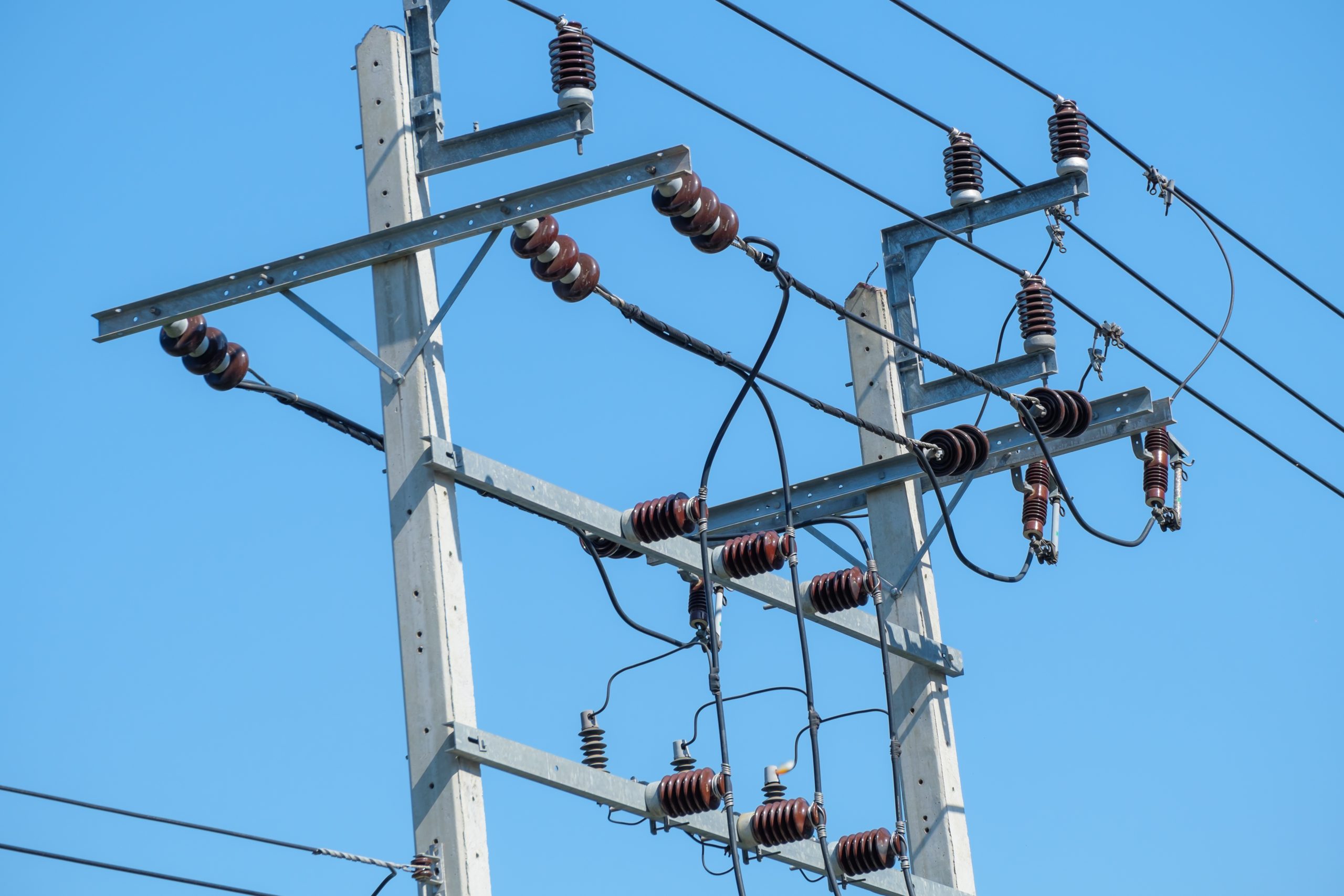 Electricity post with clear blue sky.