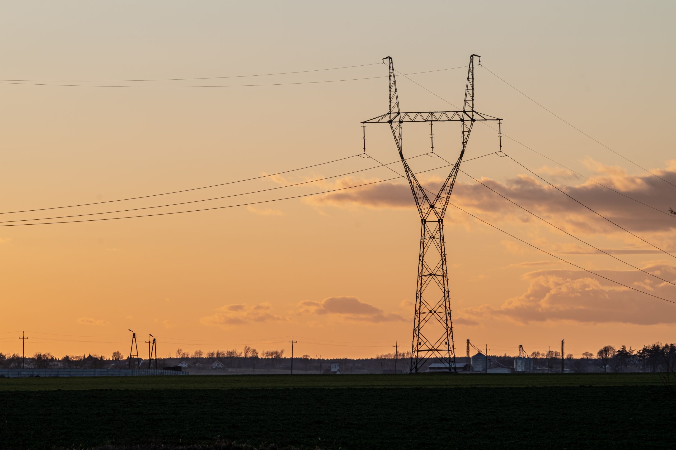 An overhead power line in the countryside at sunset
